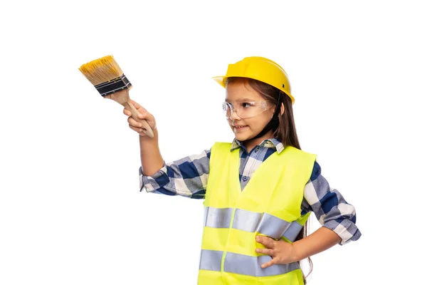 Girl in helmet and safety vest with paint brush — Stock Photo, Image