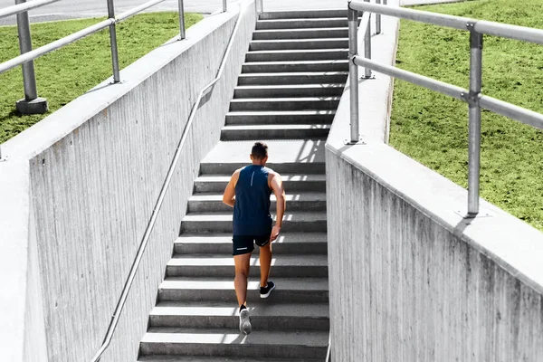 Junger Mann rennt Treppe hinauf — Stockfoto