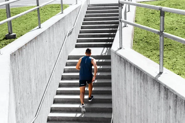 Young man running upstairs — Stock Photo, Image