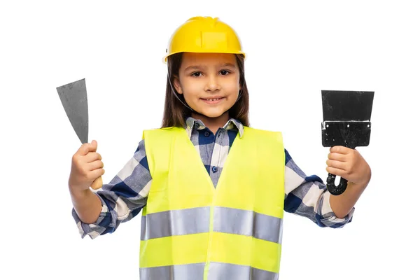 Chica en casco y chaleco de seguridad con espátulas — Foto de Stock