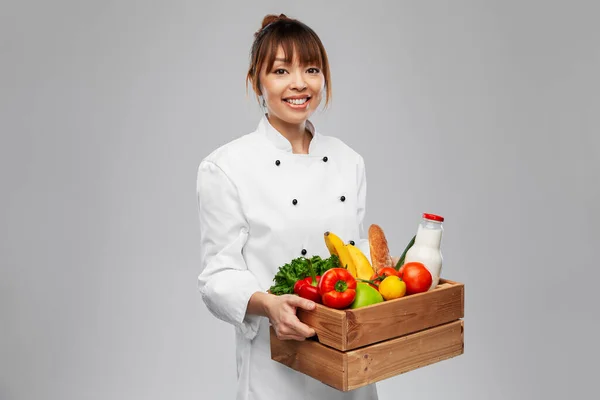 Chef feminino sorridente feliz com comida em caixa de madeira — Fotografia de Stock