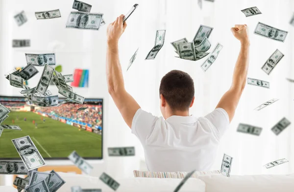 Szczęśliwy człowiek oglądając mecz piłki nożnej w telewizji na pieniądze — Zdjęcie stockowe