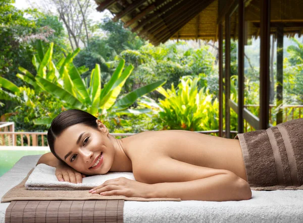 Mujer joven tumbada en el spa sobre exótico resort —  Fotos de Stock