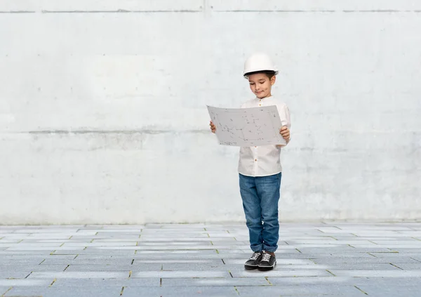 Petit garçon dans le casque de construction avec un plan — Photo