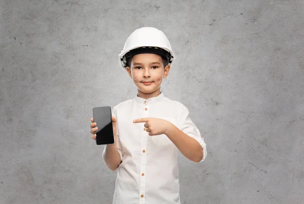 Liten pojke i konstruktion hjälm med smartphone — Stockfoto