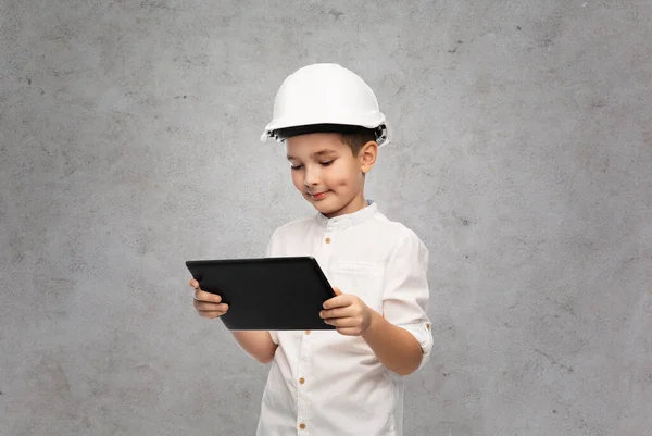 Malý chlapec ve stavební helmě s tabletem ks — Stock fotografie