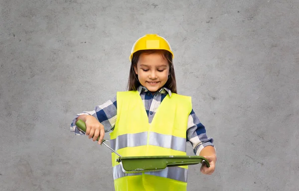 Girl in helmet and safety vest with paint roller — Stock Photo, Image