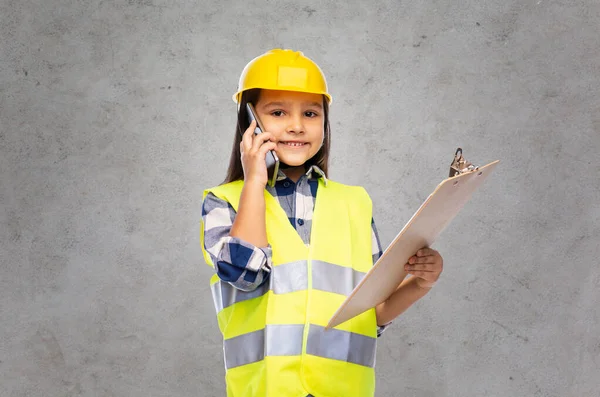 Menina no capacete com prancheta chamando no telefone — Fotografia de Stock