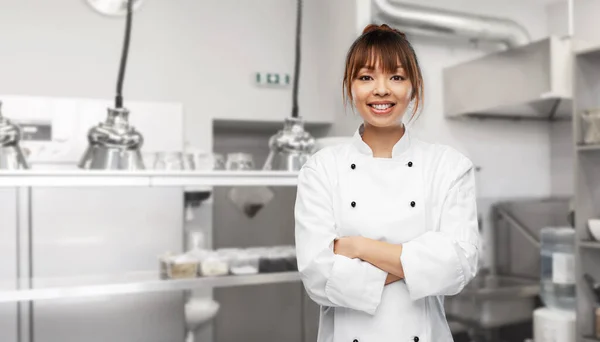 Smiling female chef at restaurant kitchen — Stockfoto