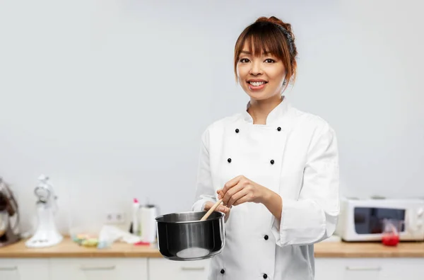 Gelukkig glimlachende vrouwelijke chef met steelpan op keuken — Stockfoto