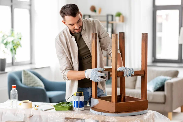 Hombre lijando mesa de madera redonda vieja con esponja —  Fotos de Stock