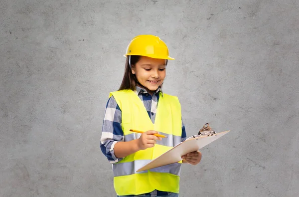 Little girl in construction helmet with clipboard Royalty Free Stock Photos