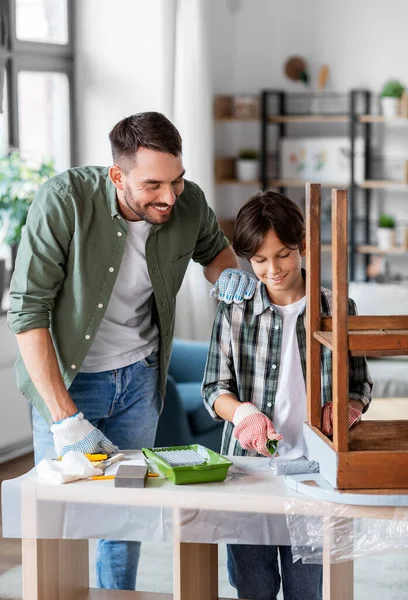 Vader en zoon schilderen oude tafel in grijze kleur — Stockfoto