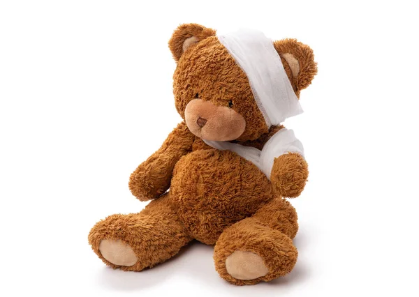 Teddy bear toy with bandaged head and paw — Stock Photo, Image