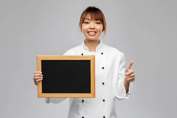 Kuchařka s tabulí ukazující palce nahoru — Stock fotografie
