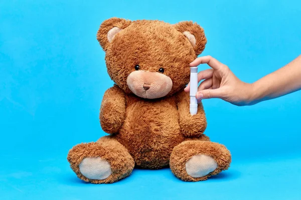 Ruce při aplikaci injekce inzulínu plyšovému medvídkovi — Stock fotografie