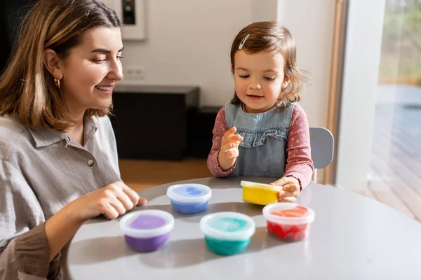 Mother and daughter playing with modeling clay — Foto Stock