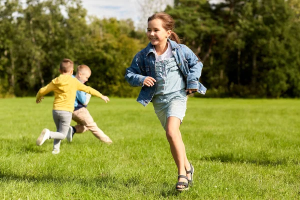 Glückliche Kinder spielen und rennen im Park — Stockfoto