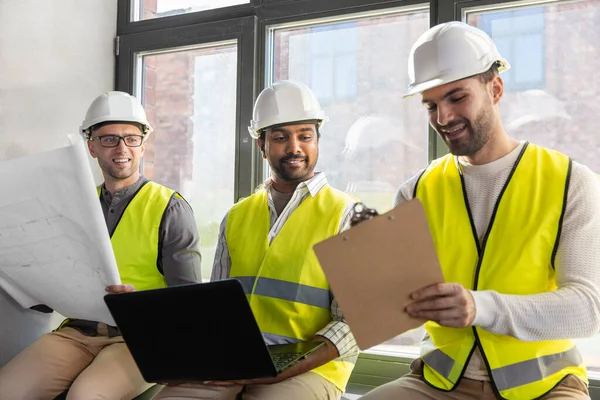 Männliche Architekten in Helmen mit Laptop im Büro — Stockfoto