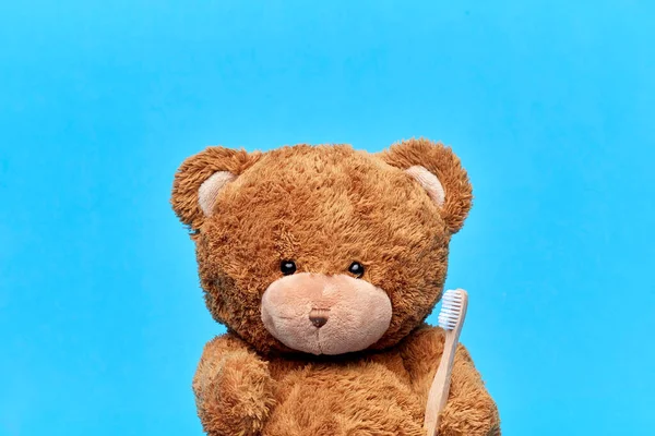 Teddy bear toy with toothbrush on blue background — Fotografia de Stock