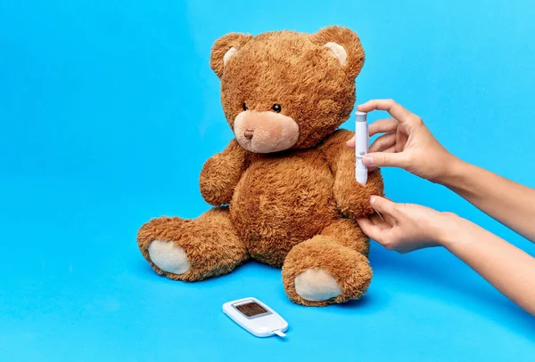 Oyuncak ayıya insülin enjekte eden eller — Stok fotoğraf