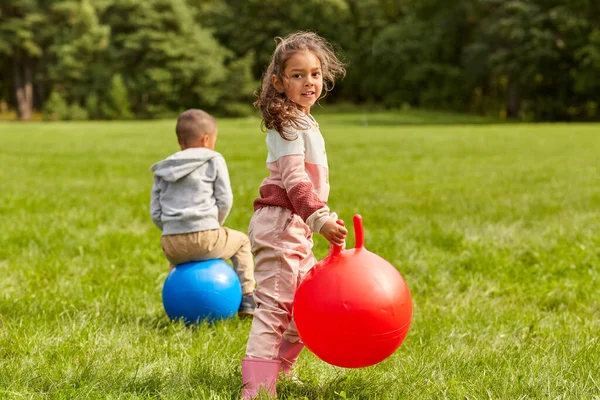 Niños felices rebotando en las bolas de la tolva en el parque —  Fotos de Stock