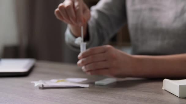 Женщина делает самотестирование коронавируса тест дома — стоковое видео