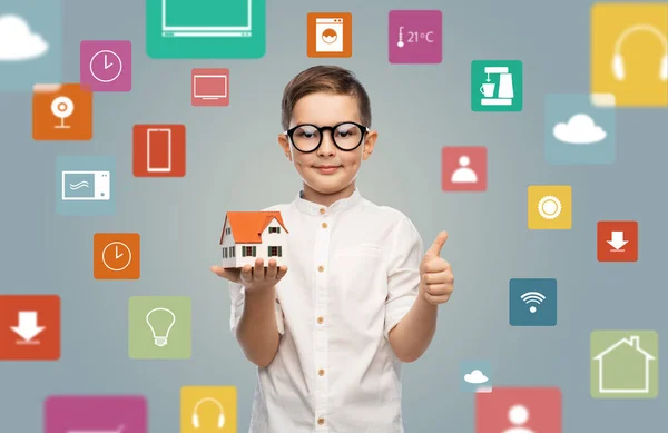 Liten pojke i glasögon med leksak hus modell — Stockfoto