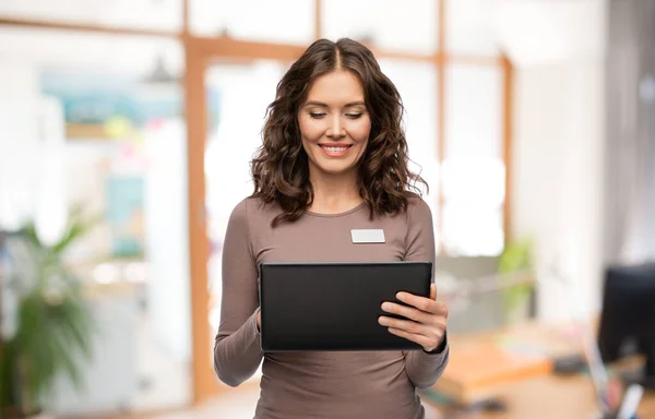 Femme heureuse avec tablette PC au bureau — Photo