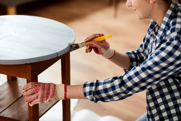 Woman painting old wooden table in grey color — Zdjęcie stockowe