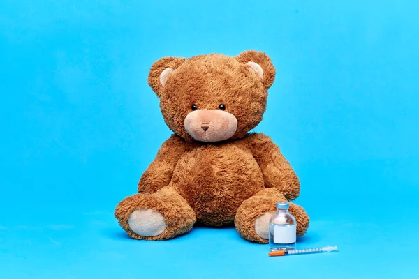 Teddy bear with vaccine or medicine and syringe — Stock Photo, Image