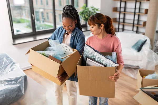 Mulheres com caixas que se mudam para casa nova — Fotografia de Stock