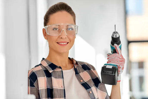 Mujer en gafas con perforador en casa — Foto de Stock