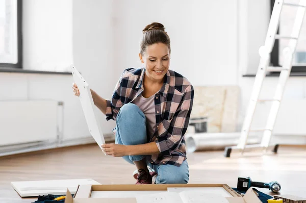 Mujer con el montaje manual de nuevos muebles en casa —  Fotos de Stock