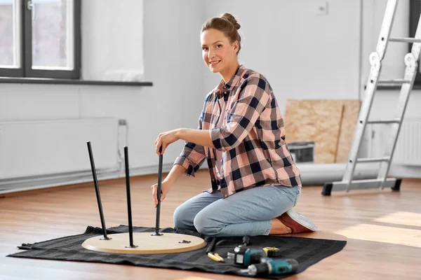 Lycklig kvinna montera soffbord på nytt hem — Stockfoto
