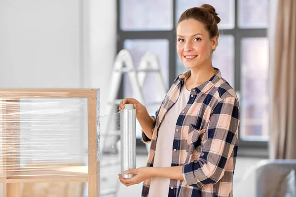 Mujer feliz estante de embalaje y mudanza a un nuevo hogar — Foto de Stock