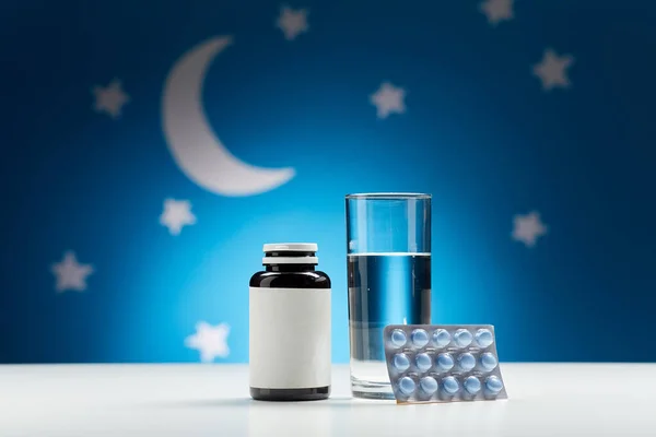 Glass of water and sleeping pills at night — Stockfoto