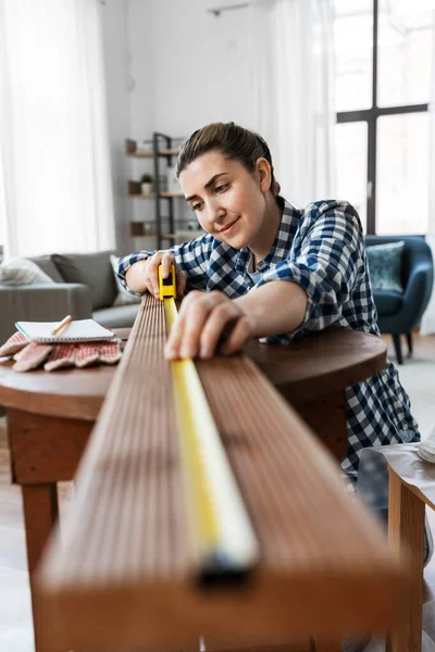 Vrouw met liniaal meten houten plaat — Stockfoto