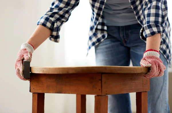 Donna levigatura vecchio tavolo rotondo in legno con spugna — Foto Stock