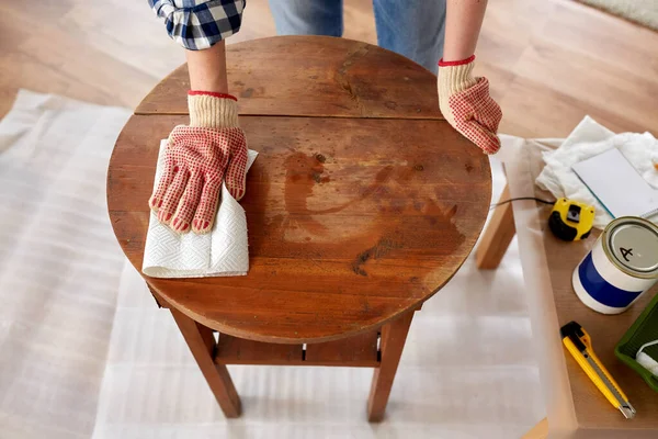 Mujer limpiando la superficie de la mesa vieja con papel —  Fotos de Stock