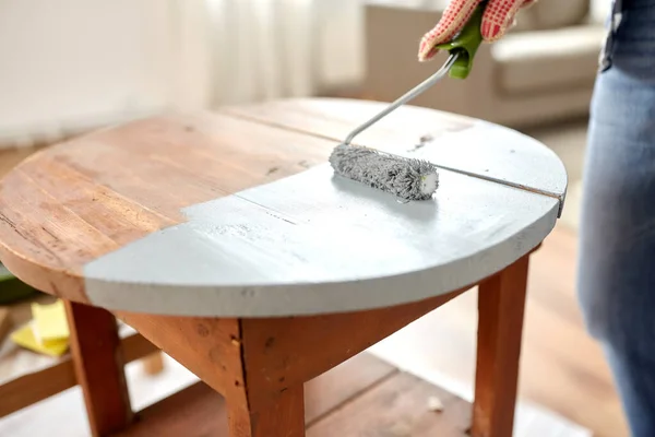 Woman painting old wooden table in grey color — Stock Photo, Image
