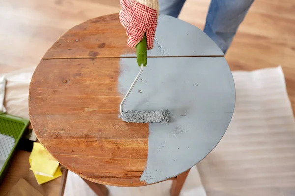 Frau bemalt alten Holztisch in grauer Farbe — Stockfoto