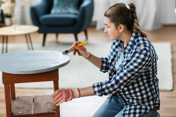 Mulher pintando mesa de madeira velha com cor cinza — Fotografia de Stock