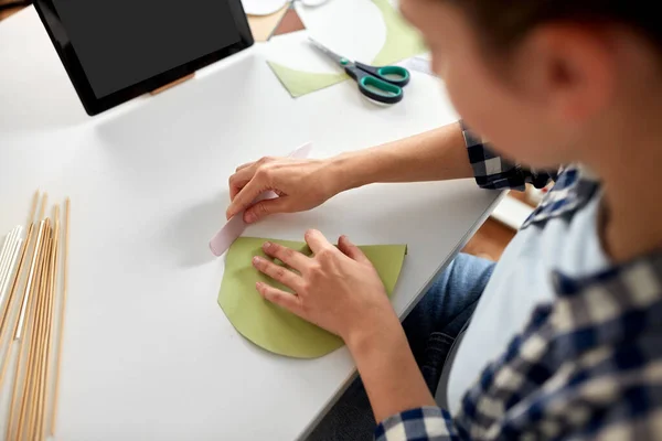 Mulher com tablet pc fazendo artesanato de papel em casa — Fotografia de Stock