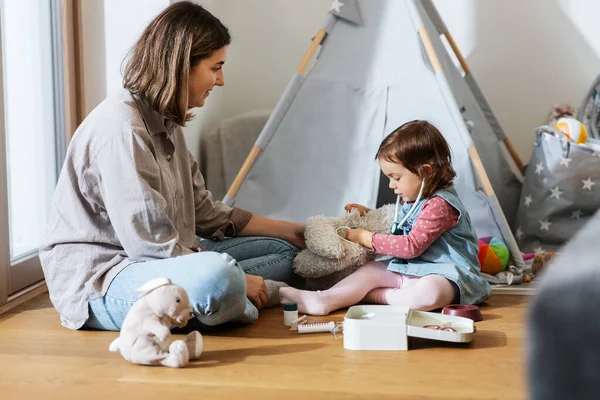 Madre e hija jugando al doctor en casa —  Fotos de Stock