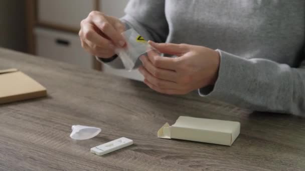 Vrouw uitpakken coronavirus test kit thuis — Stockvideo