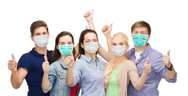 Students in protective masks showing thumbs up — Stockfoto
