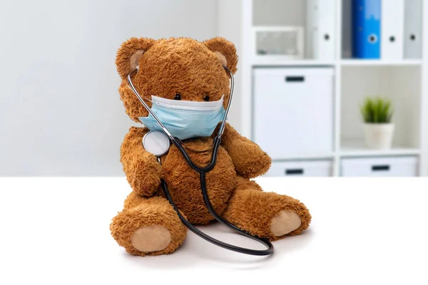 Juguete de oso de peluche en máscara médica en la clínica — Foto de Stock