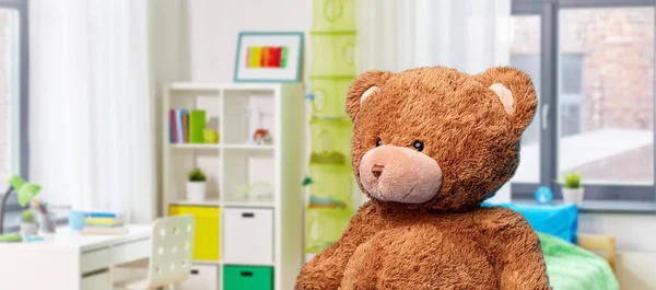 Teddy bear toy over childrens room background — Stockfoto