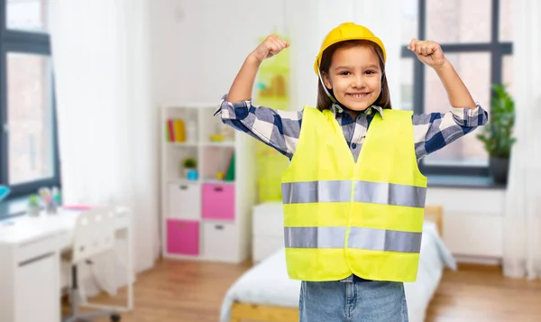 Meisje in helm en veiligheidsvest tonen kracht — Stockfoto